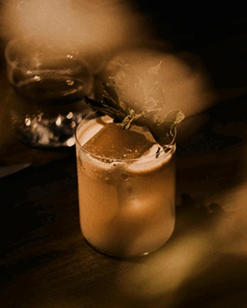 Craft cocktail garnished with herbs at Óris