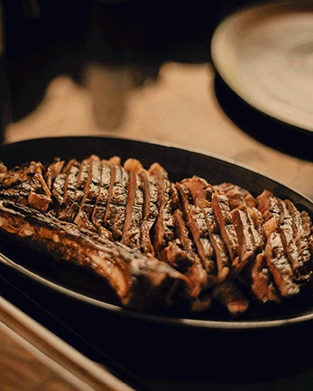 Sliced grilled meat on a plate at Óris